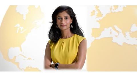 Gita Gopinath in front of globe