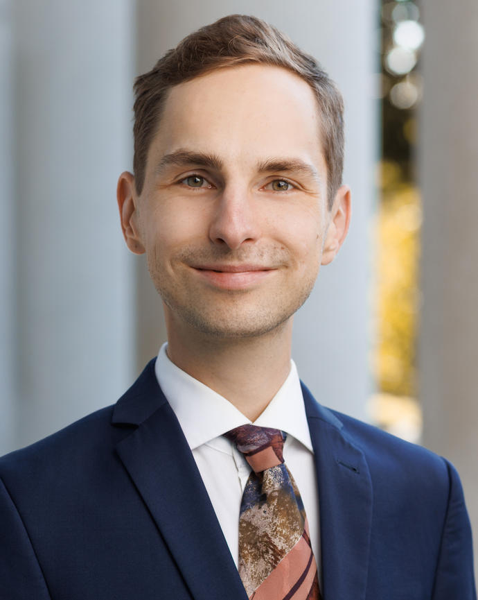Matthias Weigand headshot photo by the columns at the front of Littauer Center